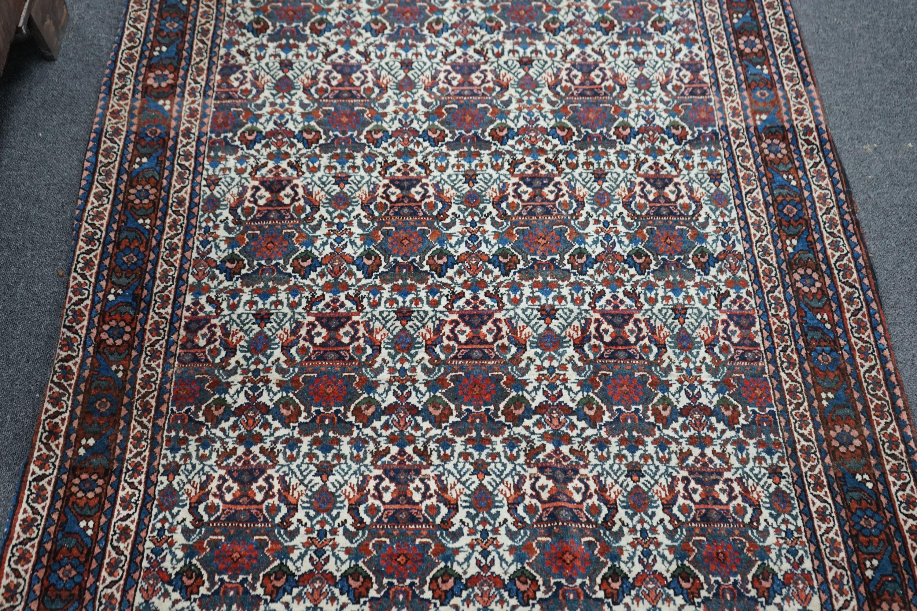 A Persian blue ground rug decorated with Zil-i-Soltan motifs on ivory fields, 106 x 152cm